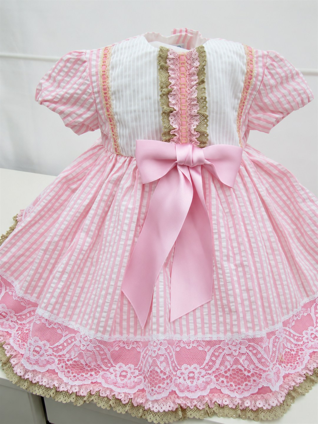 Vestido Noa rosa y blanco, con lazo y puntillas